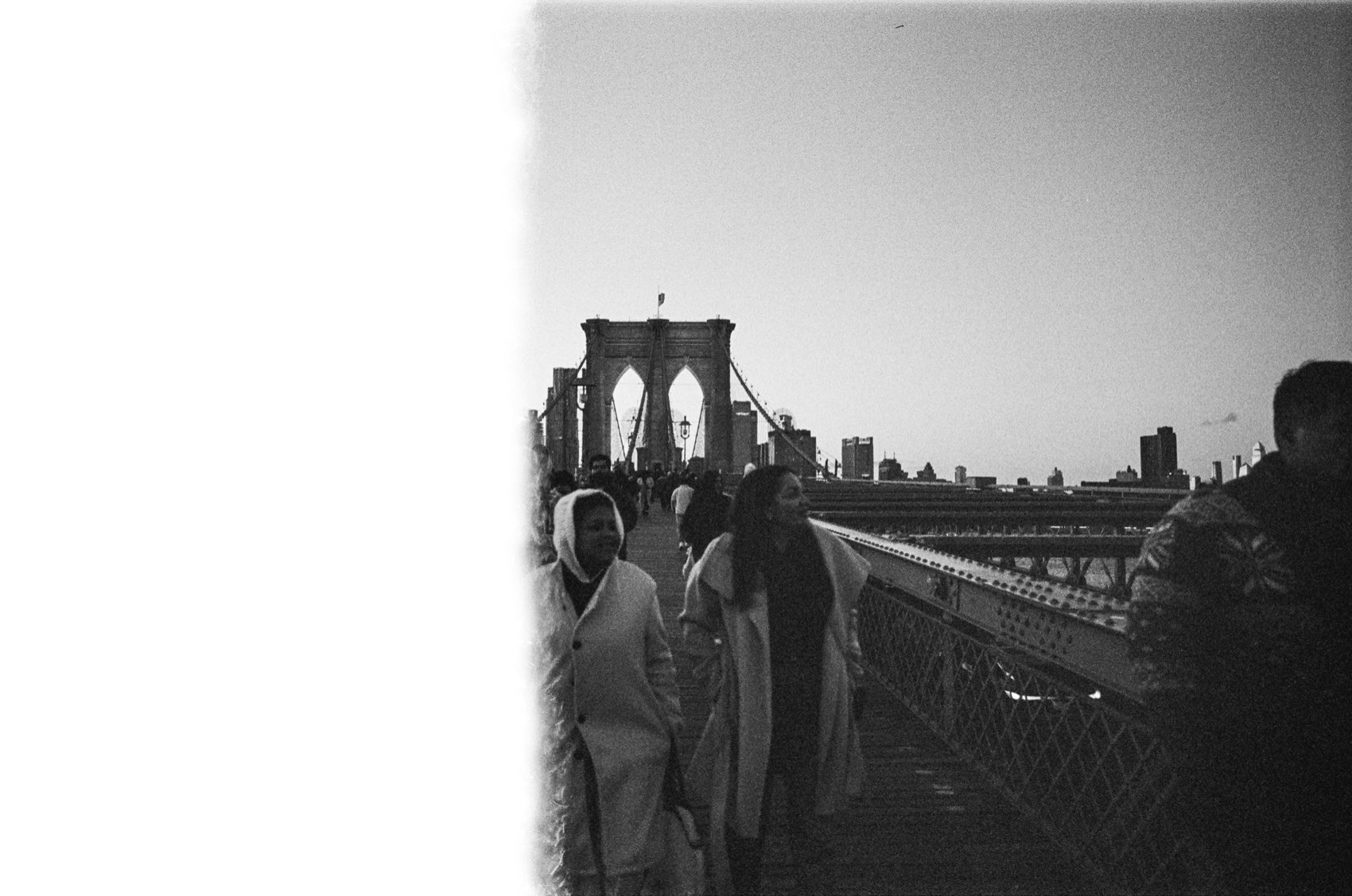 Walkers on the Brooklyn Bridge, half the frame burnt out by a light leak.
