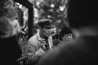 The Smoker in the Crowd. New York, Chinatown.